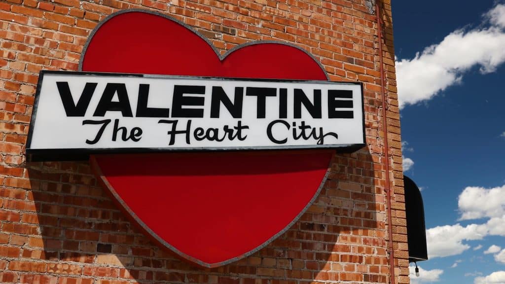 Red heart on brick wall with Valentine, The Heart City logo in Nebraska.
