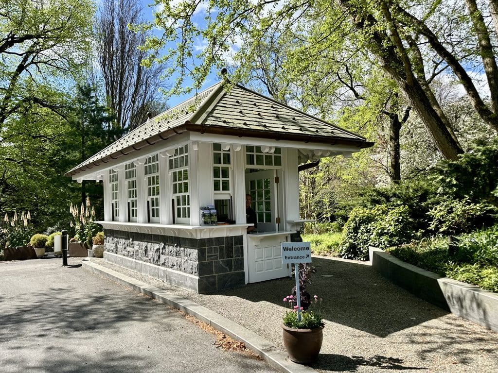 Small glass building with stone foundation at Wave Hill Garden